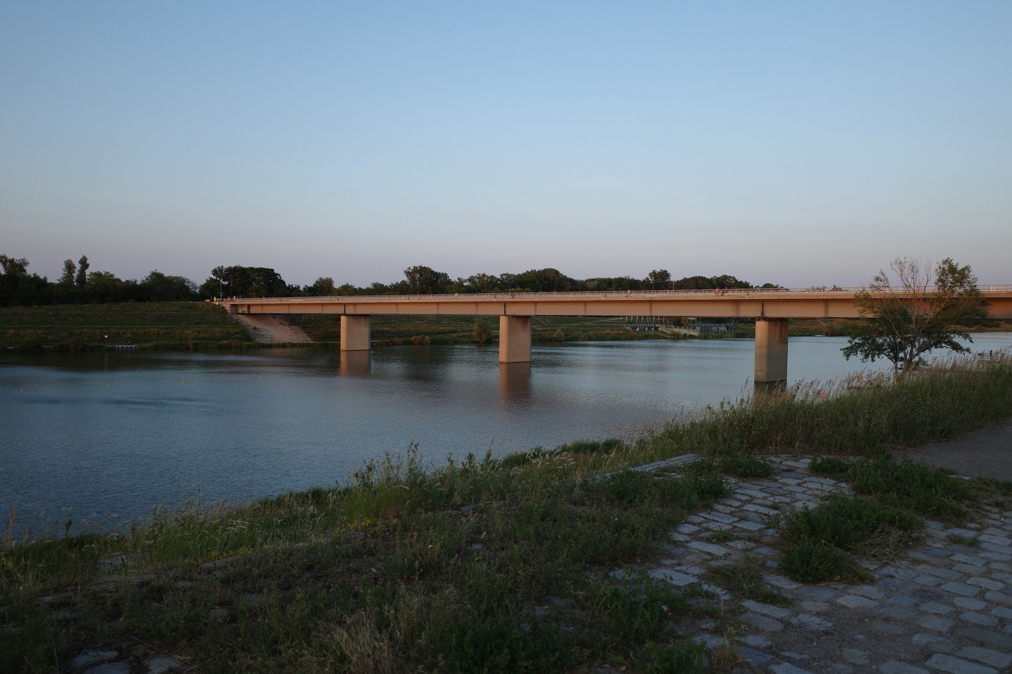 Concrete bridge over river at dusk